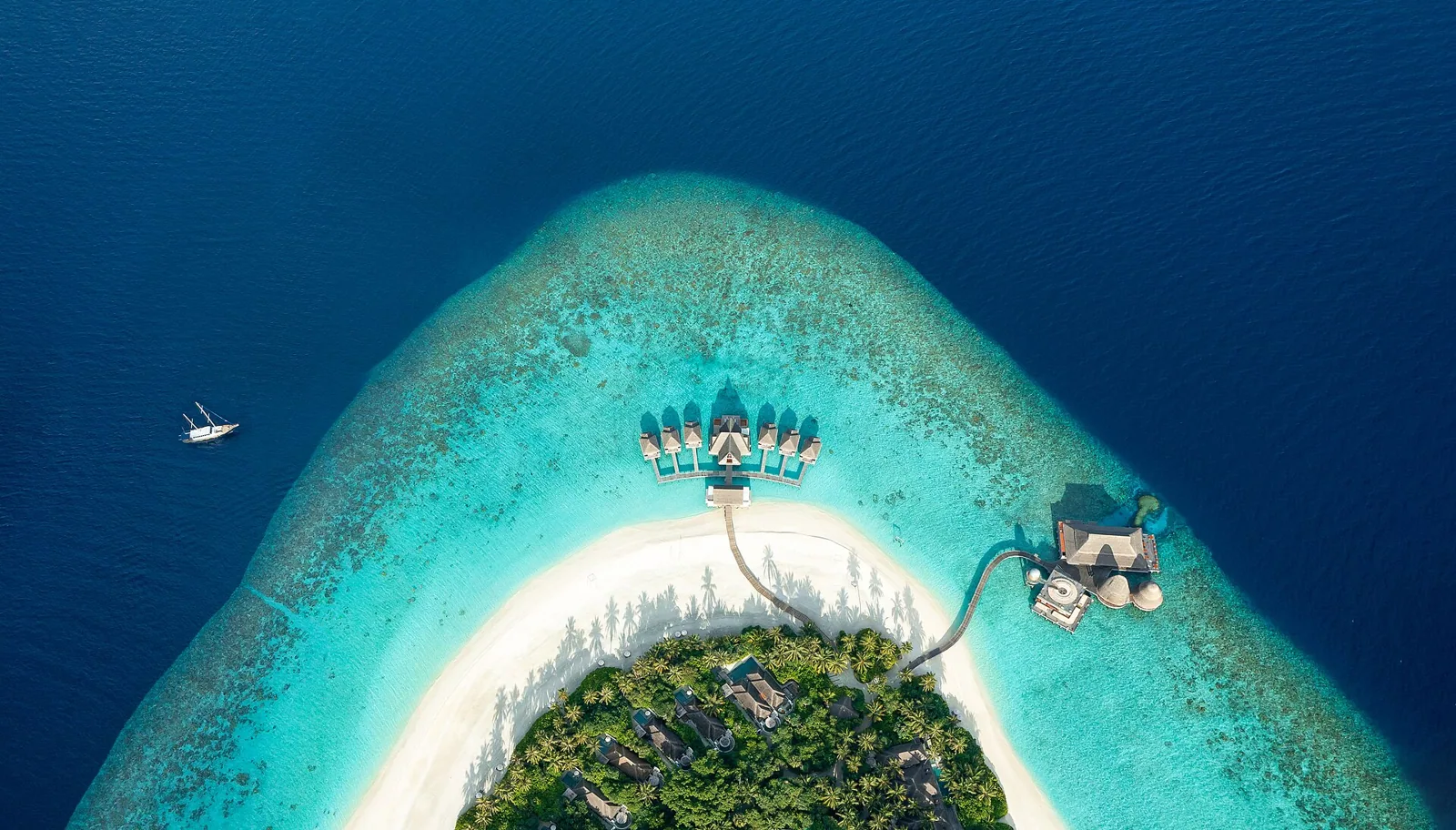 Aerial view of a private island resort on a turquoise atoll