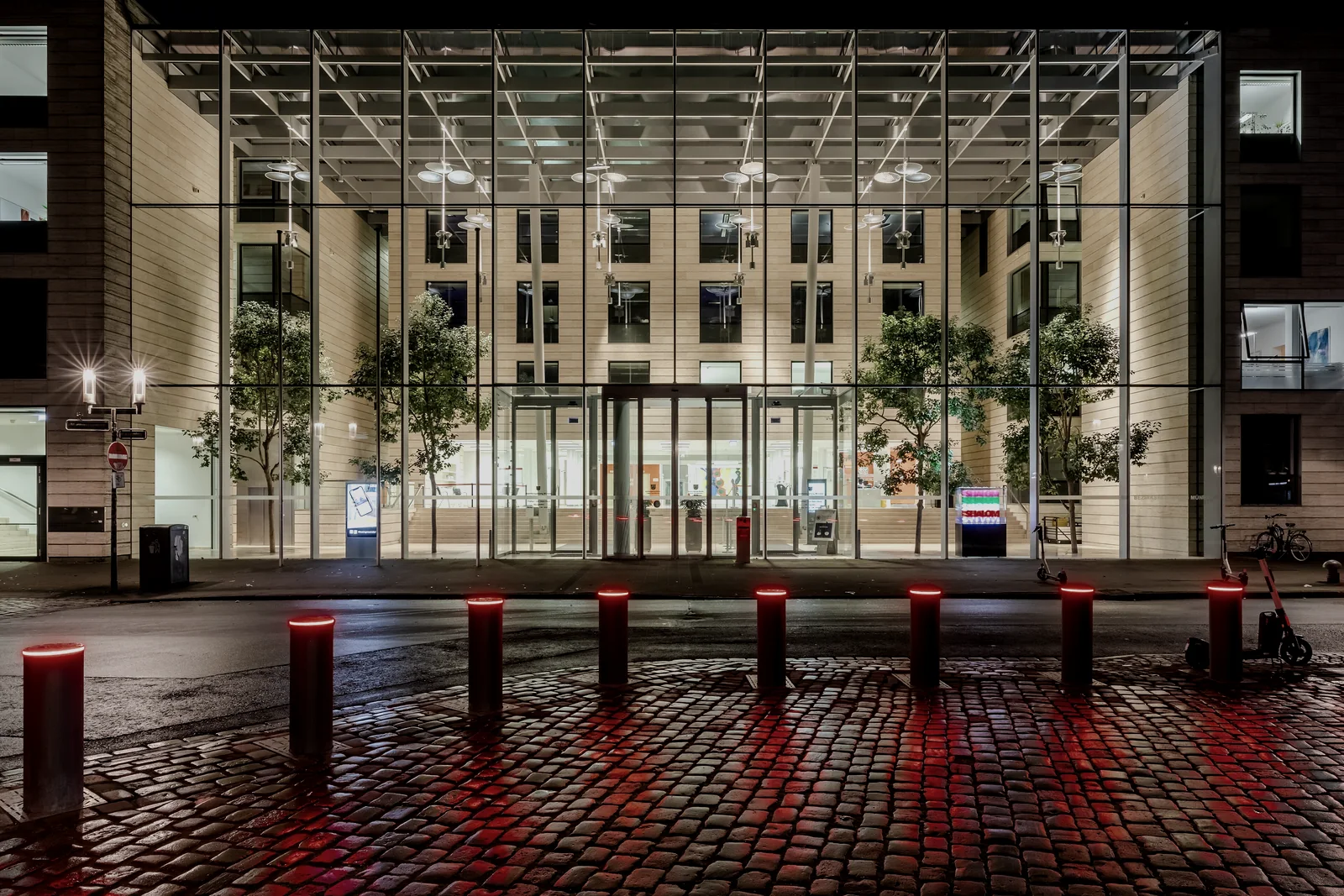 A glass pavilion lit from within at night